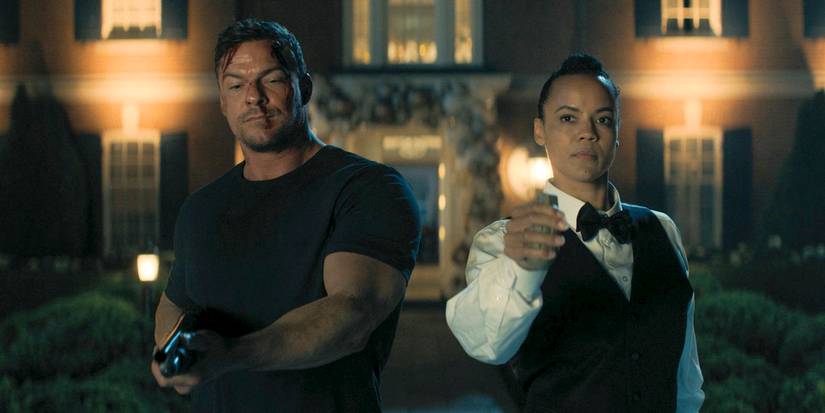 Jack Reacher (Alan Ritchson) segurando uma arma, enquanto Frances Neagley (Maria Sten) tem uma granada na mão em Reacher Temporada 3 Ep 8