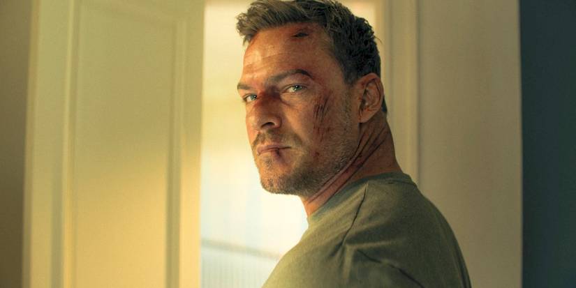 Jack Reacher (Alan Ritchson) com ferimentos no rosto, olhando por cima do ombro na 3ª temporada de Reacher.