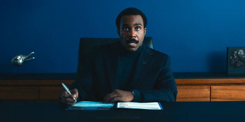 Milchick (Tramell Tillman) sitting at his desk with a notebook in Severance Season 2 Ep 9