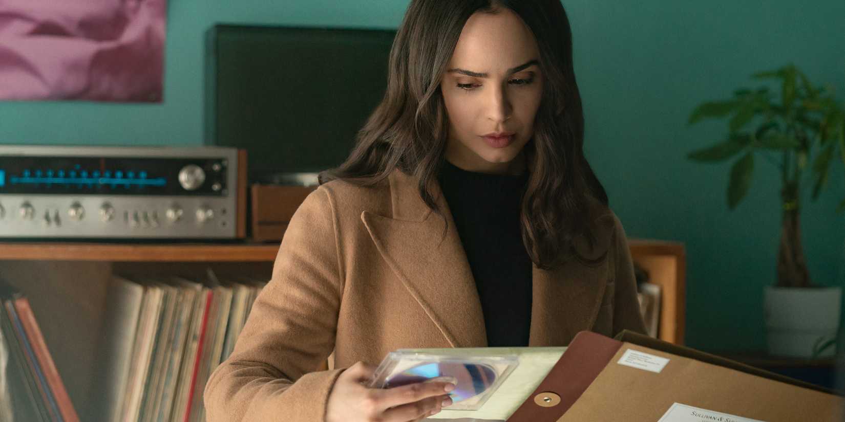 Alex looks down at an envelope and DVD in The Life List