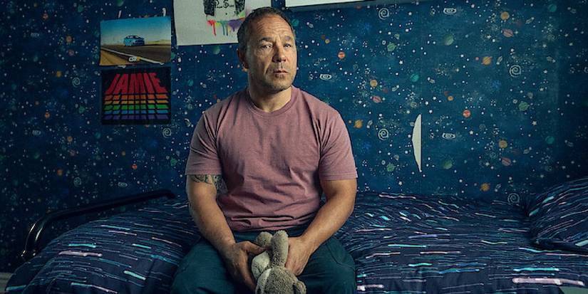 Stephen Graham as Eddie Miller sitting on Jamie's bed holding a stuffed toy in the Adolescence finale