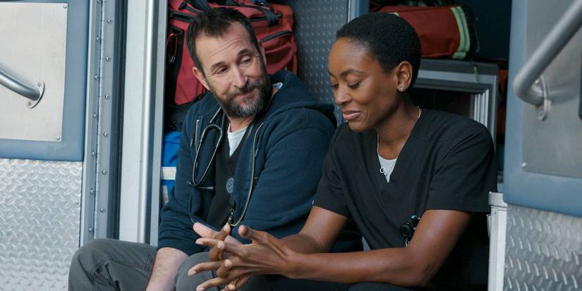 Dr. Robi (Noah Wyle) and Dr. Heather Collins (Tracy Ifeachor) talking while sitting in the cabin of an ambulance in The Pitt Season 1 Ep 11