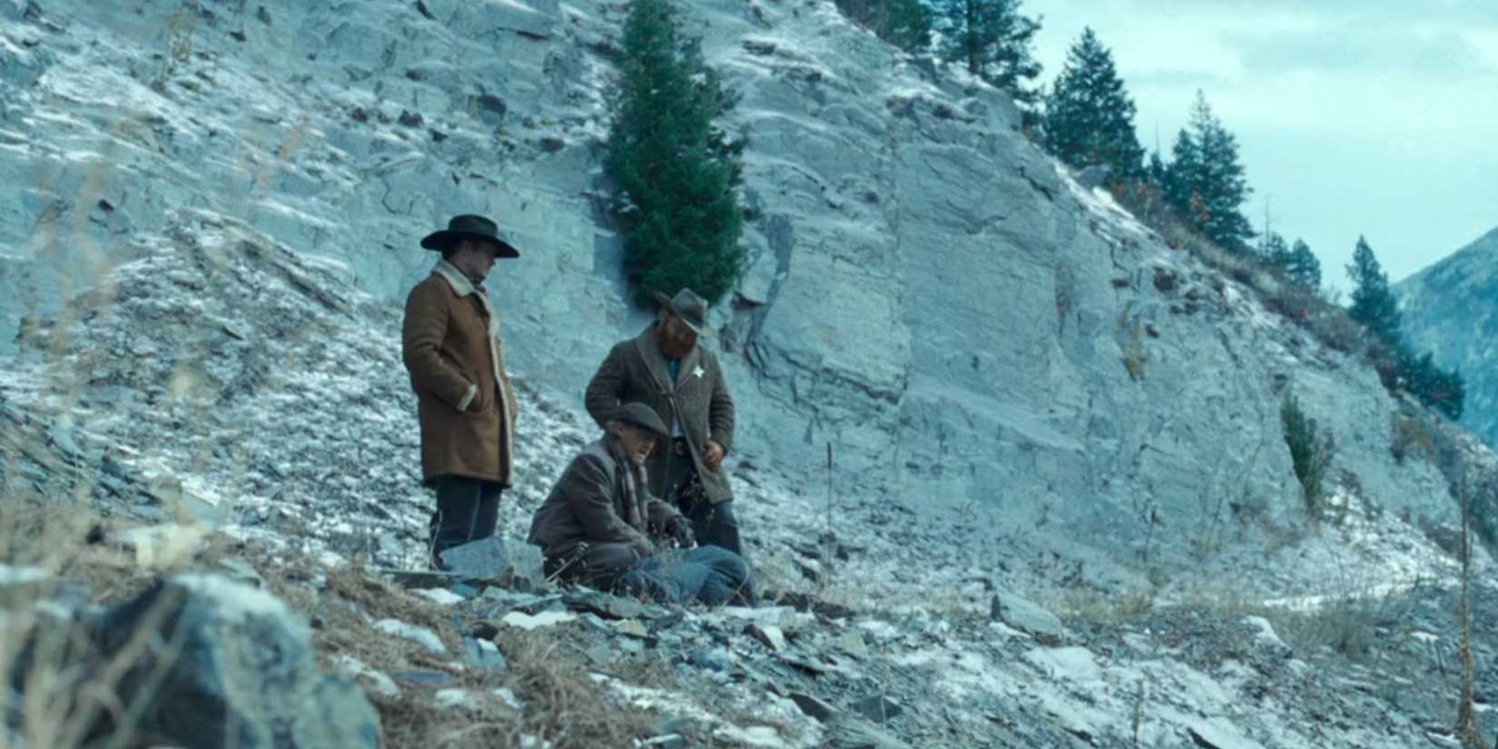 Three men surround a dead body wrapped in a blanket at the Train Station in 1923 season 2, episode 5