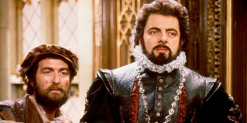Rowan Atkinson como Blackadder e Sir Tony Robinson como Baldrick em pé e olhando para algo fora da tela em Blackadder II.