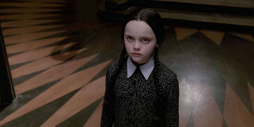 Wednesday Addams (Christina Ricci) looking up at someone in The Addams Family.