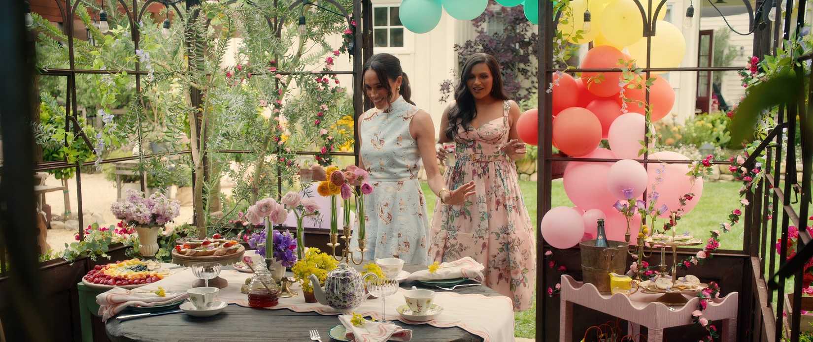 Meghan Markle e Mindy Kaling em uma festa de chá colorida.