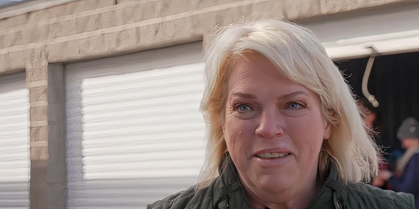 Janelle Brown with her hair down in front of an open garage on Sister Wives