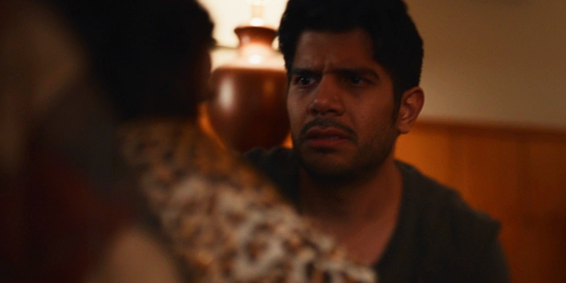 Adult Travis nervously looking at Natalie in Yellowjackets season 2 flashback