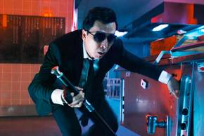 Donnie Yen as Caine crouching down behind a countertop in John Wick: Chapter 4