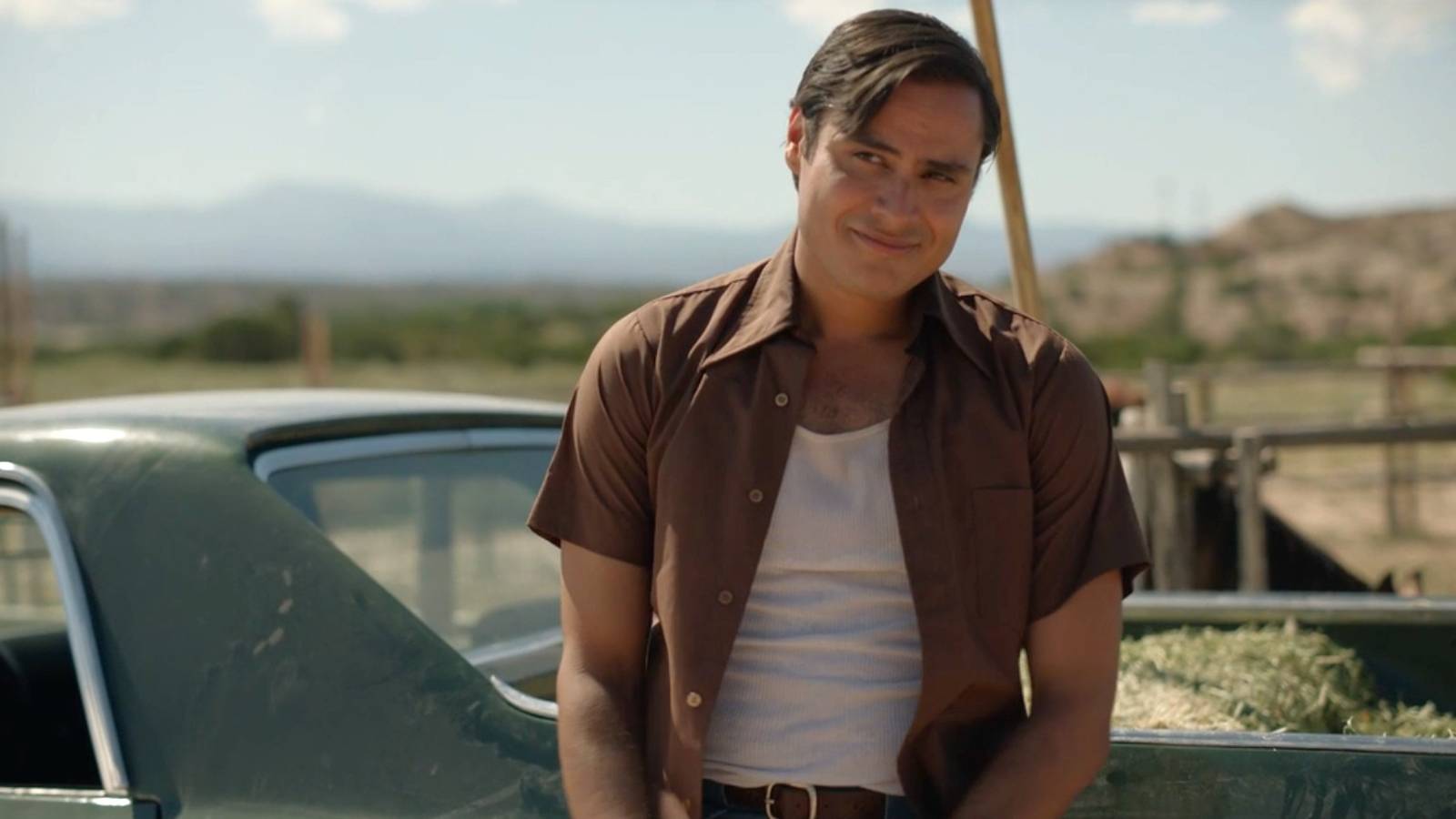 Jim Chee (Kiowa Gordon) smiling while leaning against a truck in Dark Winds season 3, episode 8