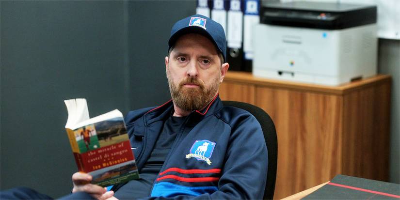 Coach Beard segurando um livro em 3x01.
