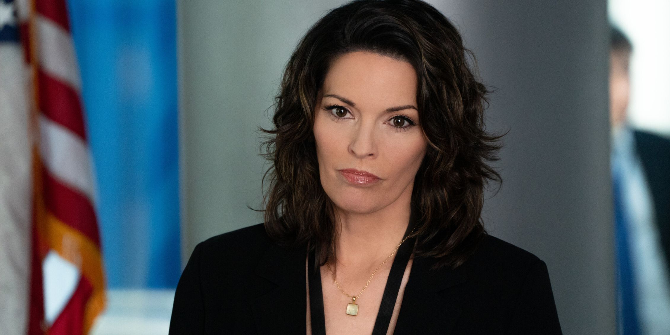 FBI Isobel standing by a flag