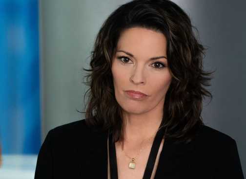 FBI Isobel standing by a flag