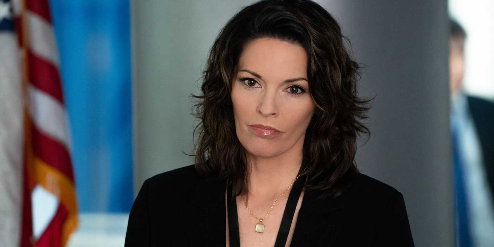 FBI Isobel standing by a flag