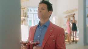 Glenn Howerton as Ethan looking smug while holding two glasses in Sirens