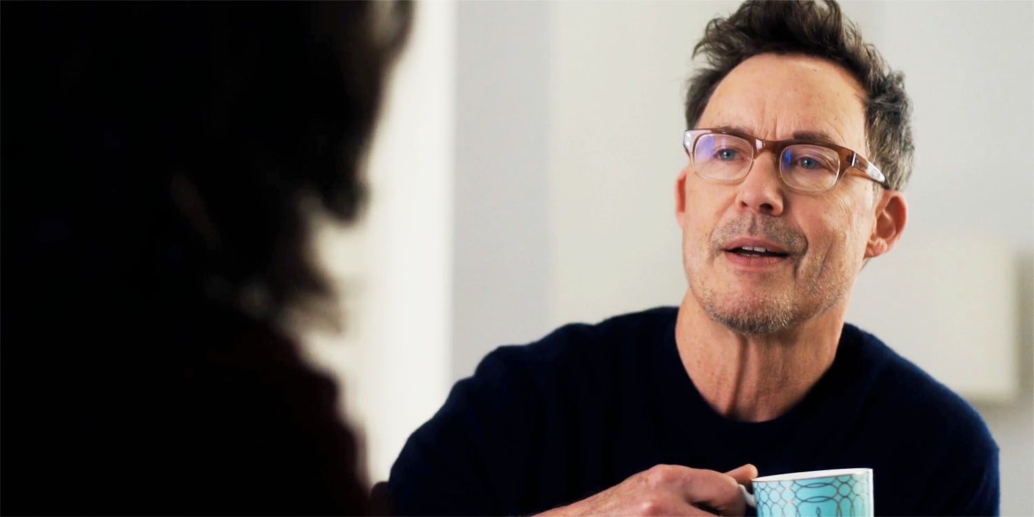 Isobel's husband holding a cup in FBI