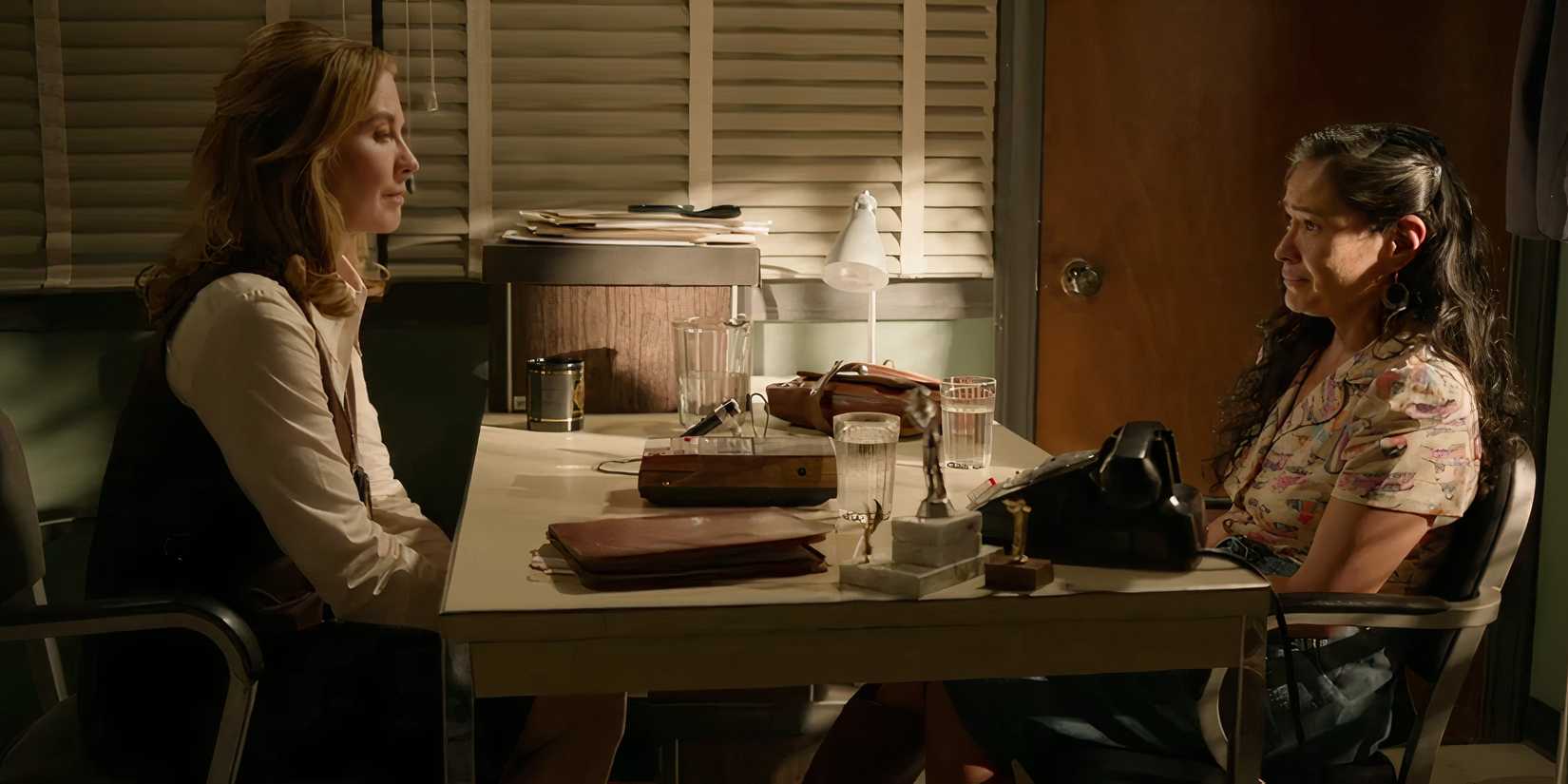 Jenna Elfman's Agent Washington & Deanna Allison's Emma Leaphorn sit across a table from each other in Dark Winds season 3