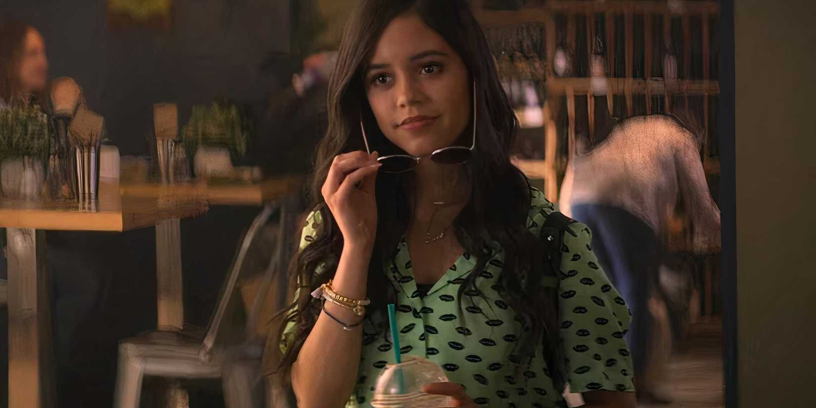 Jenna Ortega como Ellie em Você, removendo seus óculos escuros.