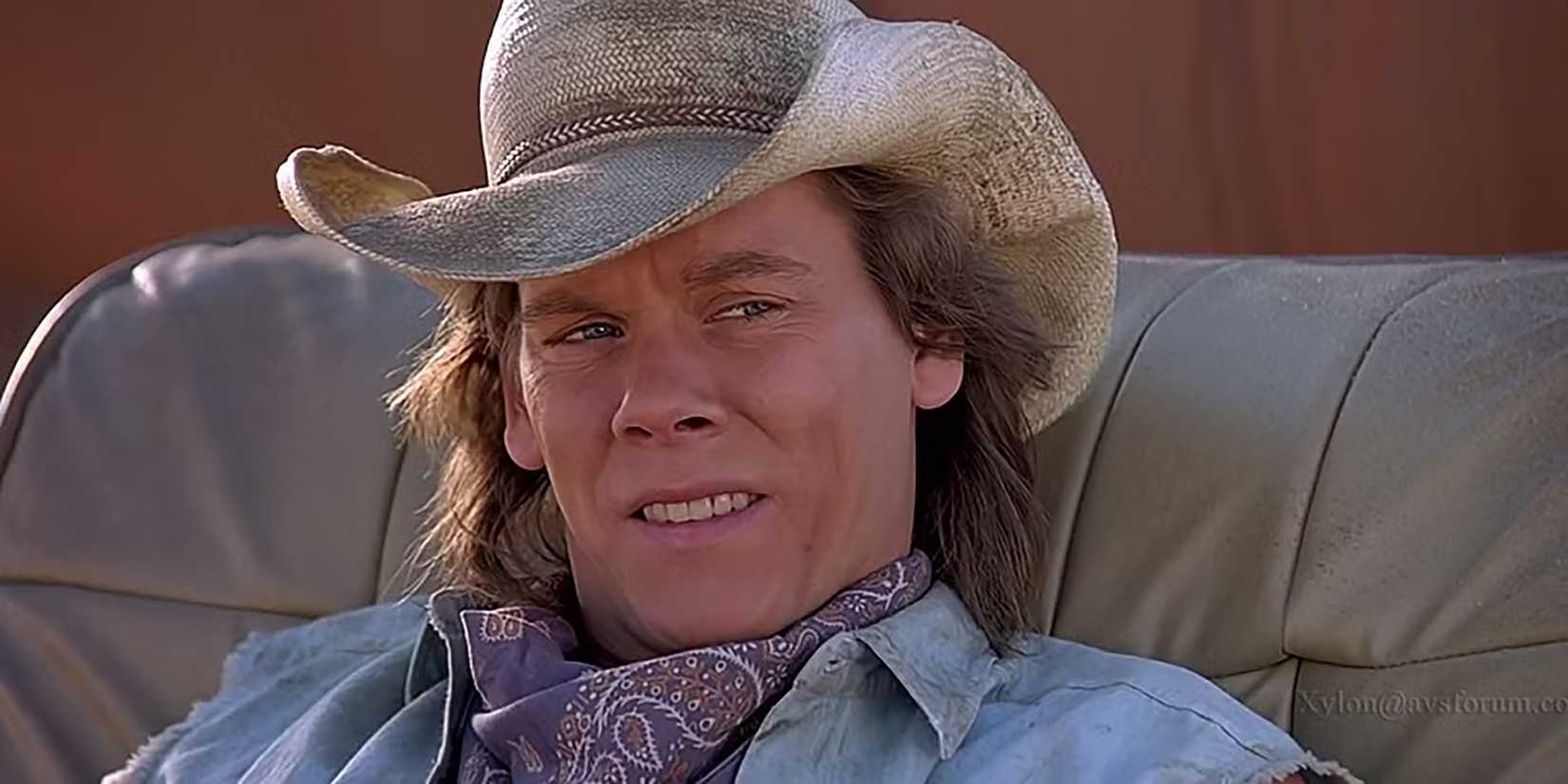 Kevin Bacon as Val looking uncertain while sitting in a chair in Tremors