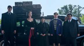 Lurch, Morticia, Wednesday, Pugsley, and Gomez Addams standing in front of their car in Wednesday season 2