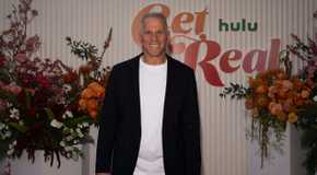 The Golden Bachelor's Mel Owens at a press event wearing a black suit jacket and white shirt