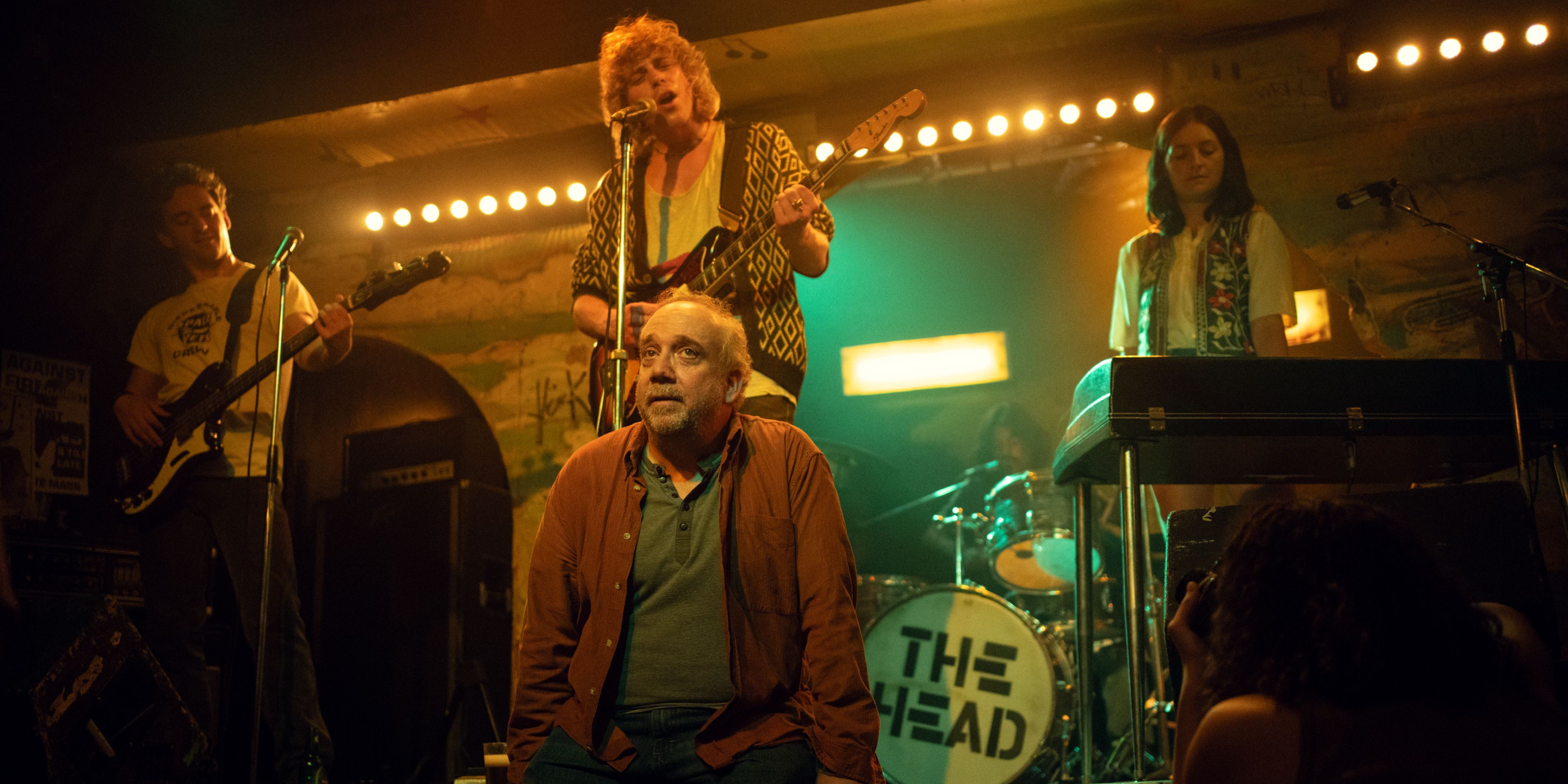 Phillip sitting in a simulated memory of his band performing in Black Mirror season 7 episode 5