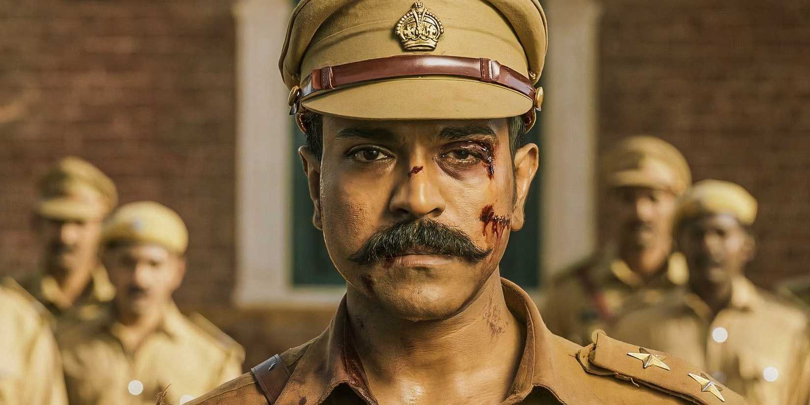One of Ram Charan's eyes is bloodied as he stares into the camera with a sad look.