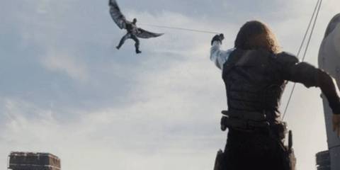 Sebastian Stan as The Winter Soldier pulling Anthony Mackie as Falcon down in Captain America_ The Winter Soldier