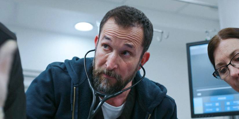 Dr. Robi (Noah Wyle) listening with a stethoscope in The Pitt Season 1 Ep 15