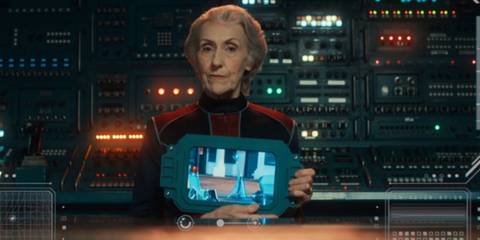 Anita Dobson holding a tablet as Mrs. Flood in Doctor Who