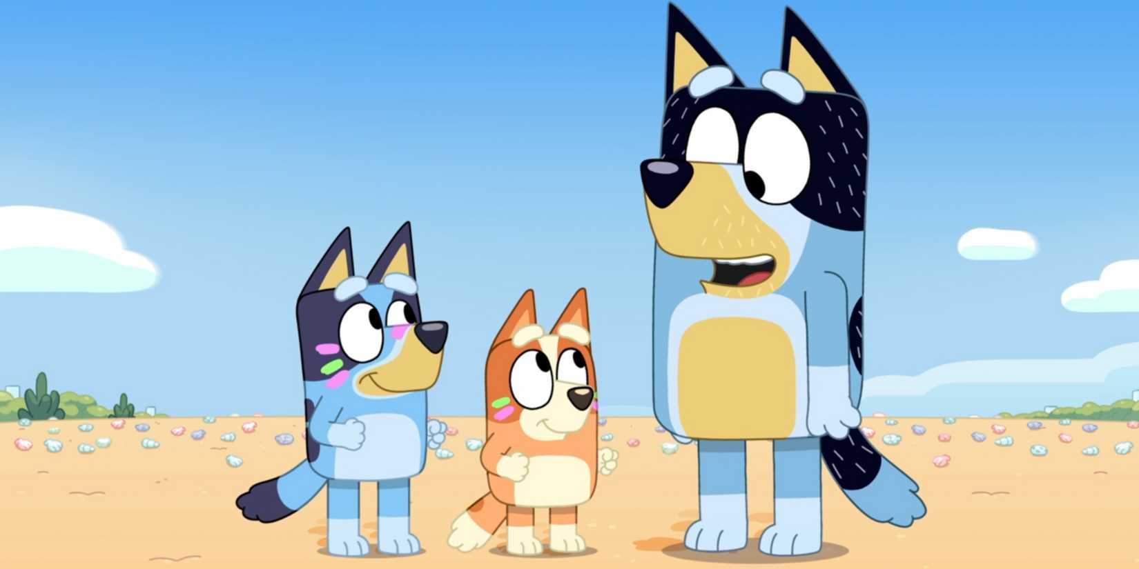 Bandit talking on a beach with Bluey and Bingo