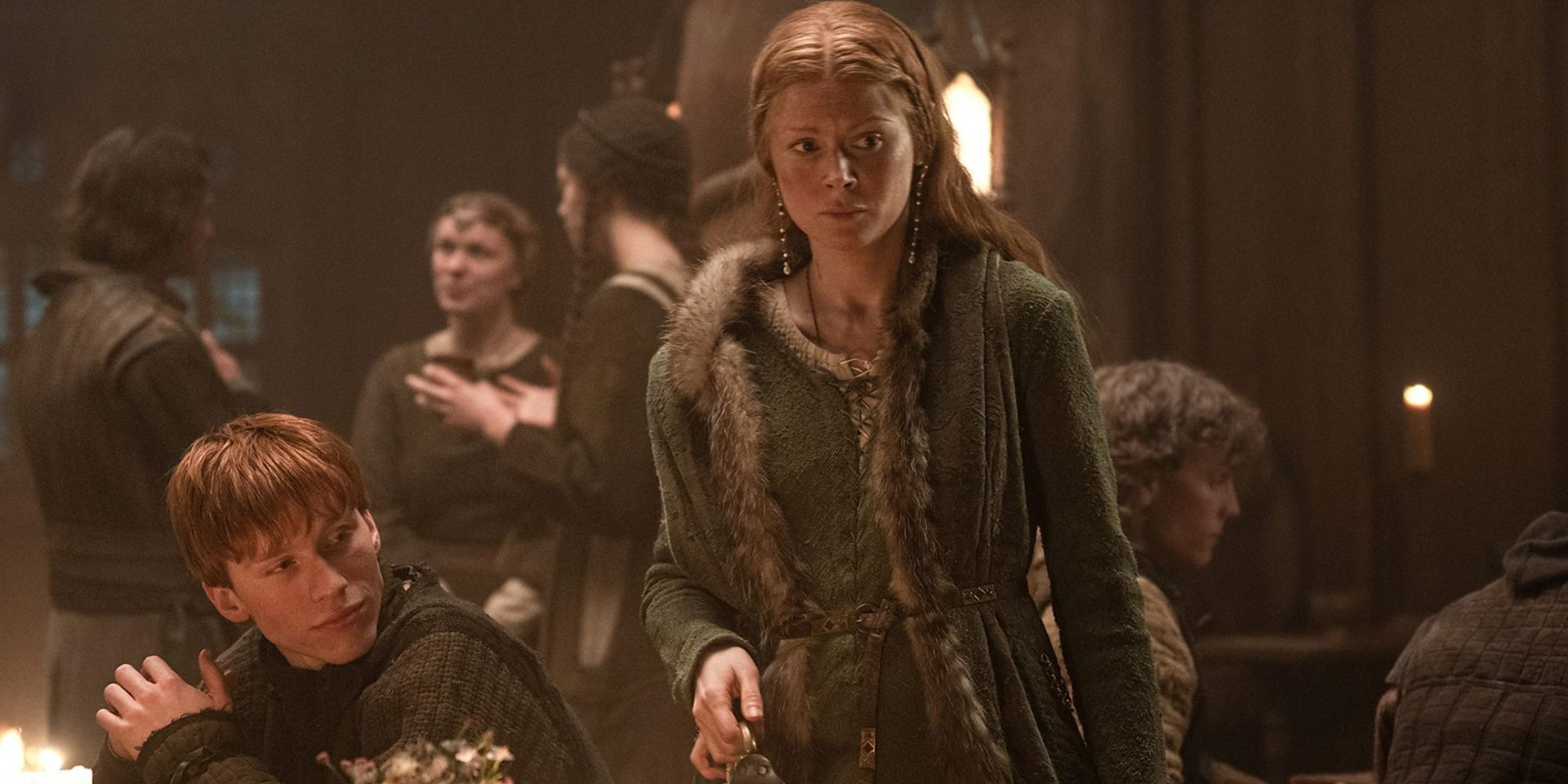 Emily Beecham as Edith Swan-neck pouring a pitcher next to a seated Luther Ford as Tostig