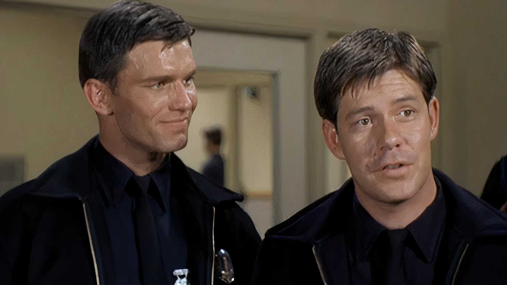Kent McCord as Jim Reed looking and smiling at Claude Johnson as Brinkman 