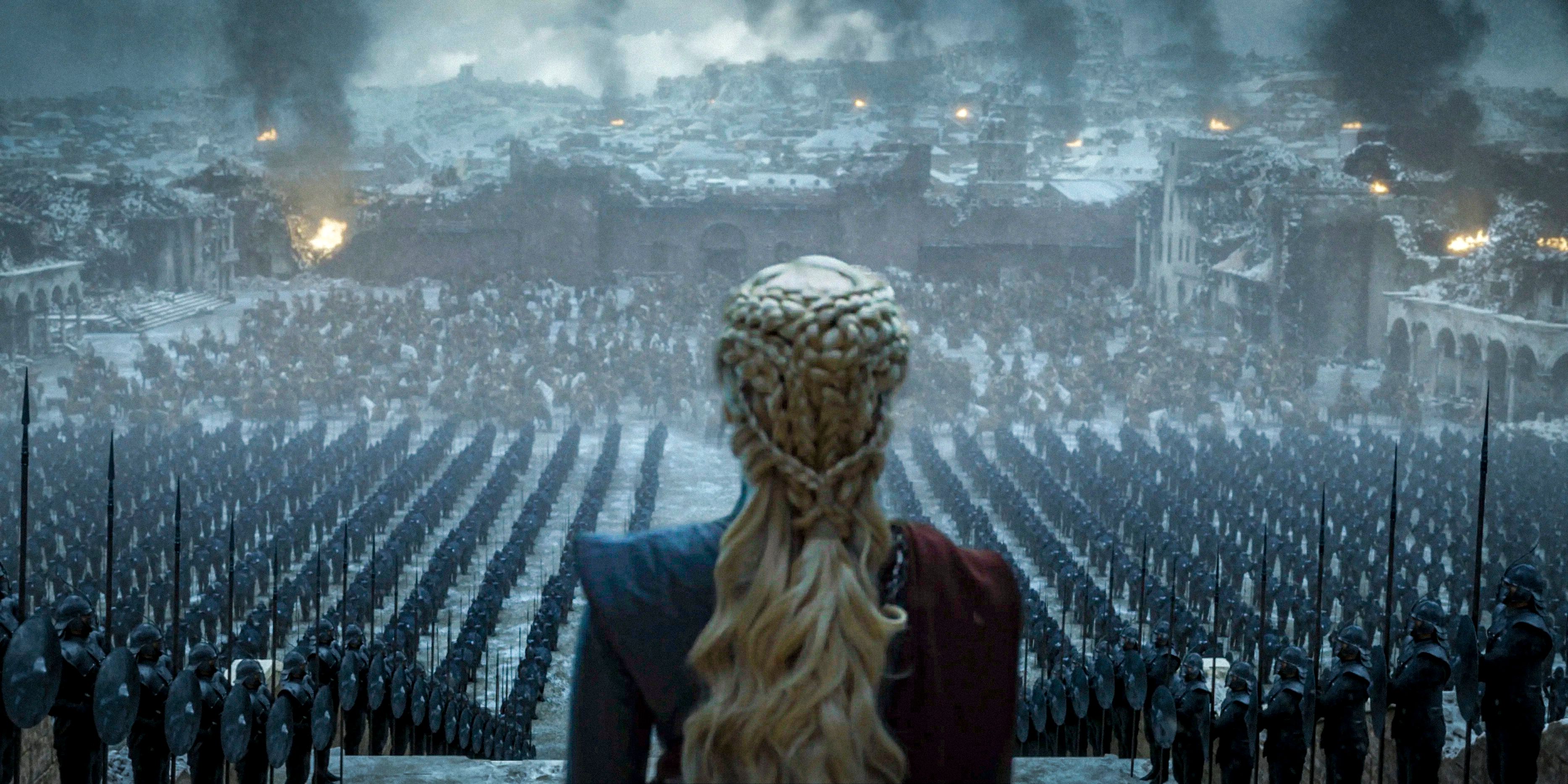 Emilia Clarke as Daenerys Targaryen looking down at her army and destruction in Game of Thrones.