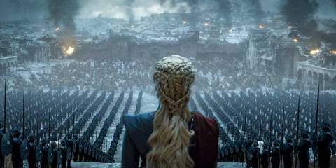 Emilia Clarke as Daenerys Targaryen looking down at her army and destruction in Game of Thrones.