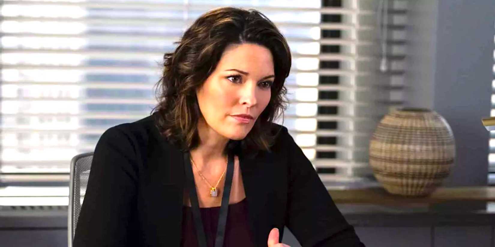 Alana de la Garza's Isobel sits at a desk frowning in FBI season 7