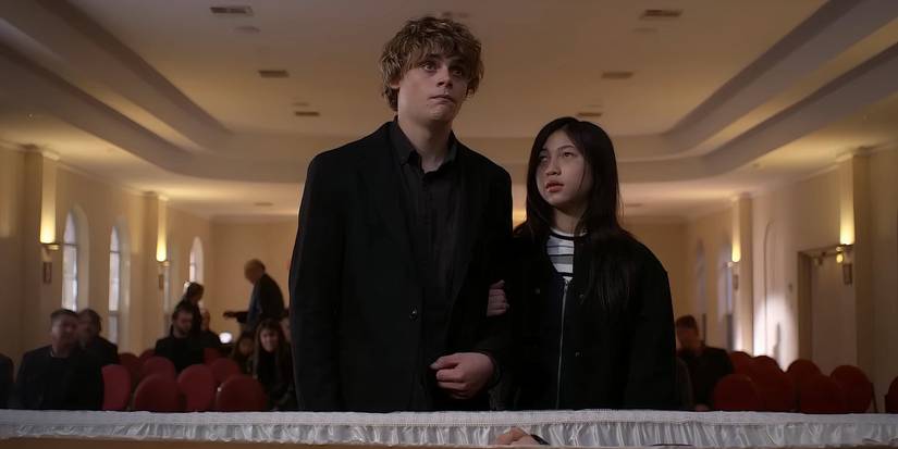 Andy and Piper standing together in front of a casket in Bring Her Back