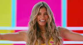Love Island USA's Belle-A Walker smiling broadly against a colorful background