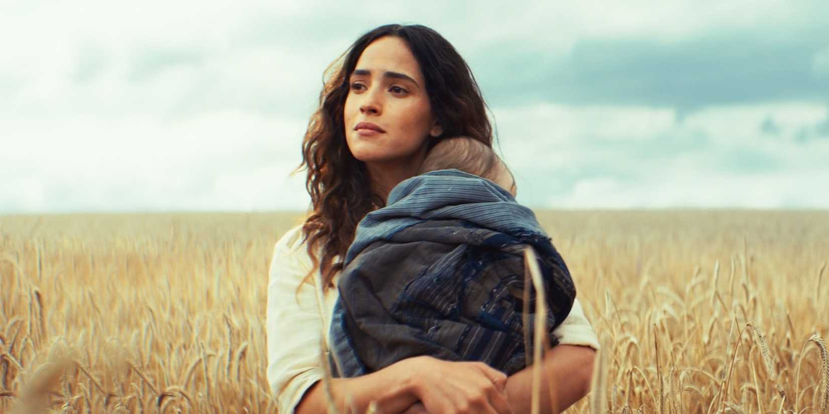 Bix Holding Cassian Andor's Child in a Wheat Field