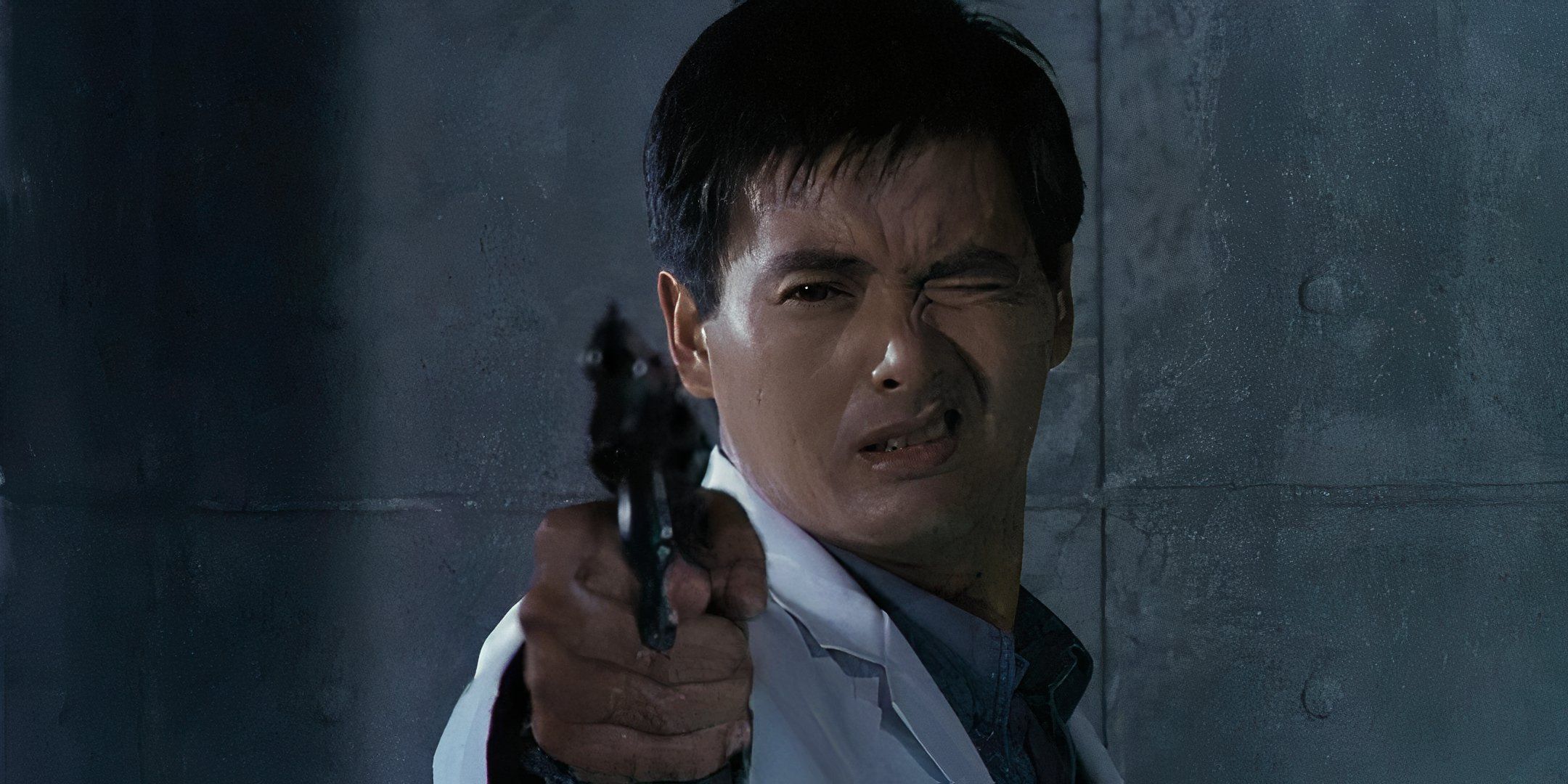 Chow Yun-Fat closes one eye and points a gun.  