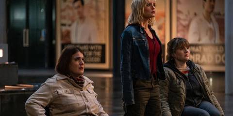 Ruby Sunday, Shirley, and Shirley's friend, standing in the street with Conrad posters behind them as Earth starts being destroyed, in Doctor Who's 