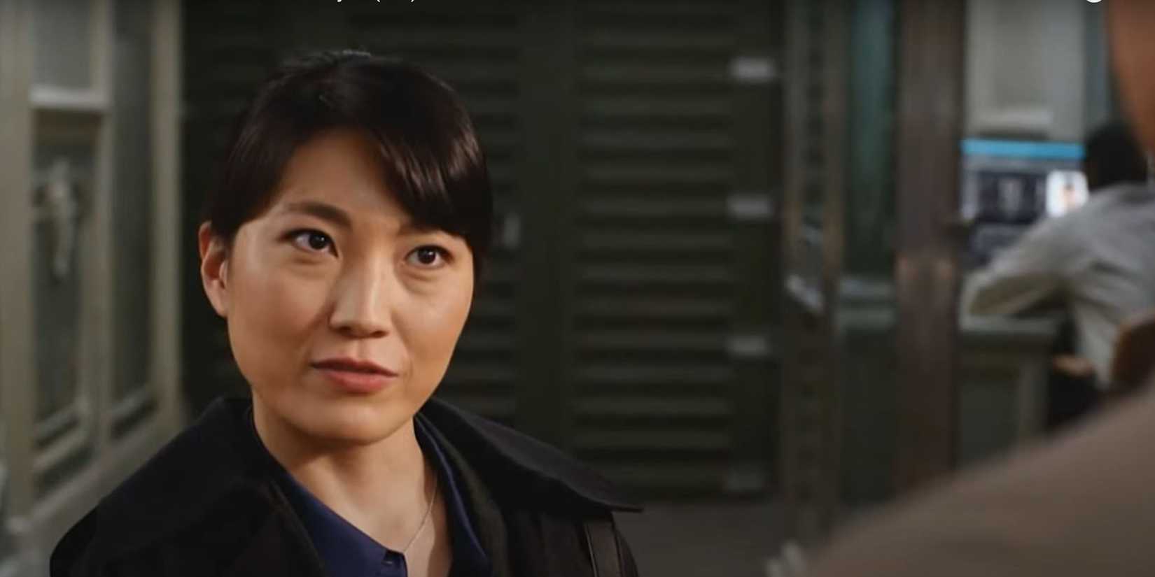 FBI International Japanese Agent Reiko Isokawa standing in a room