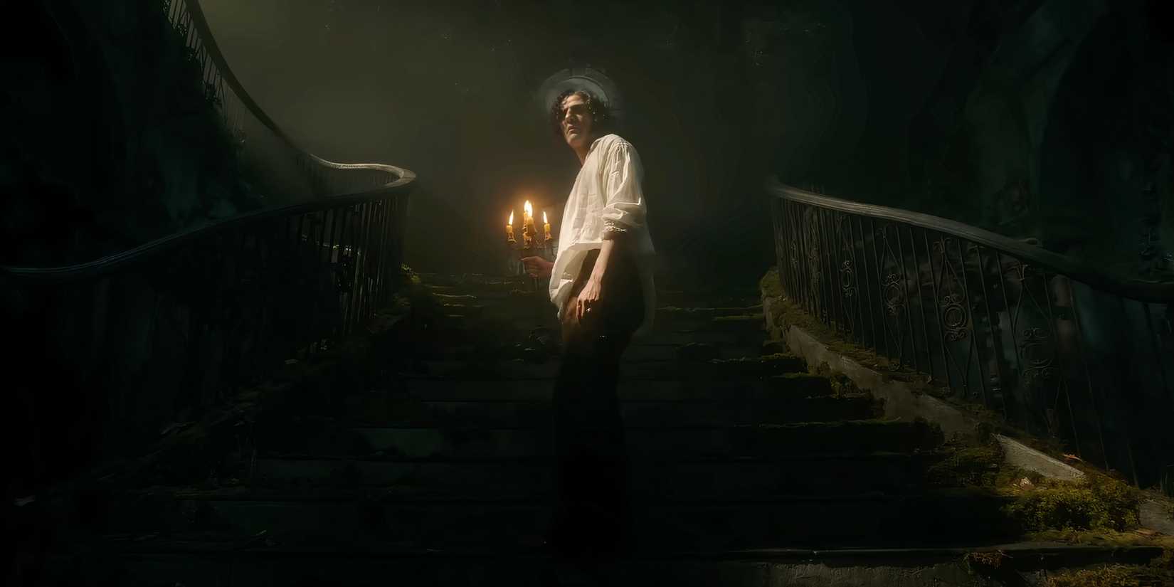 Oscar Isaac holding candles as Victor Frankenstein in Frankenstein