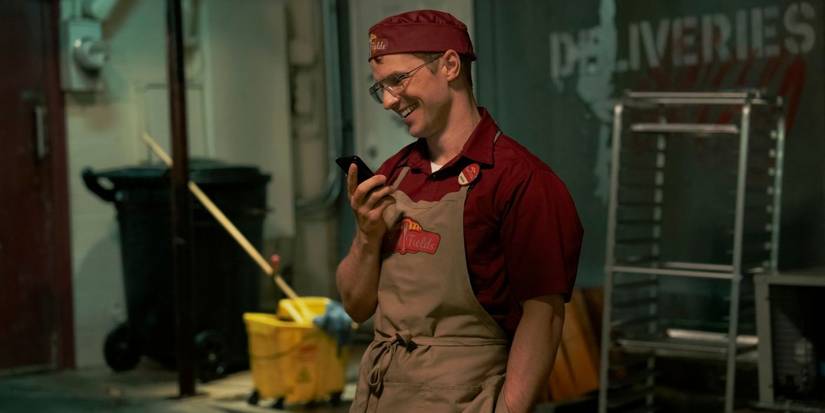 Freddie Stroma smiling as Adrian Chase in Peacemaker season 2