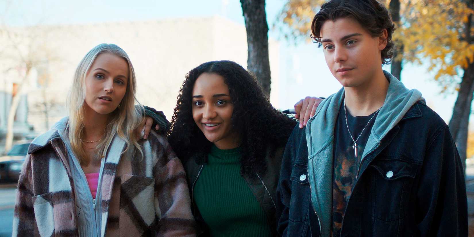 Janet, Ronnie and Cole stand together outdoors in Clown in a Cornfield