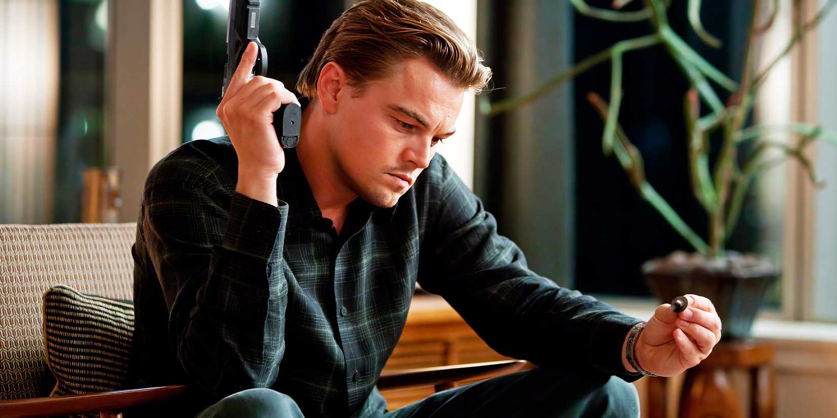 Leonardo DiCaprio as Dom Cobb holding a gun in Inception