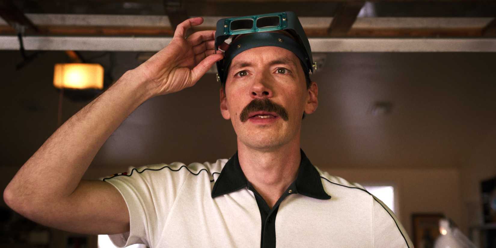 Mr Clarke lifting up his classes in a garage in Stranger Things season 3