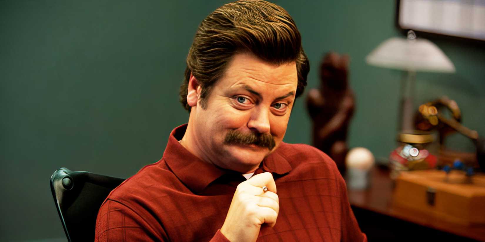 Nick Offerman como Ron Swanson sorrindo em Parks and Recreation