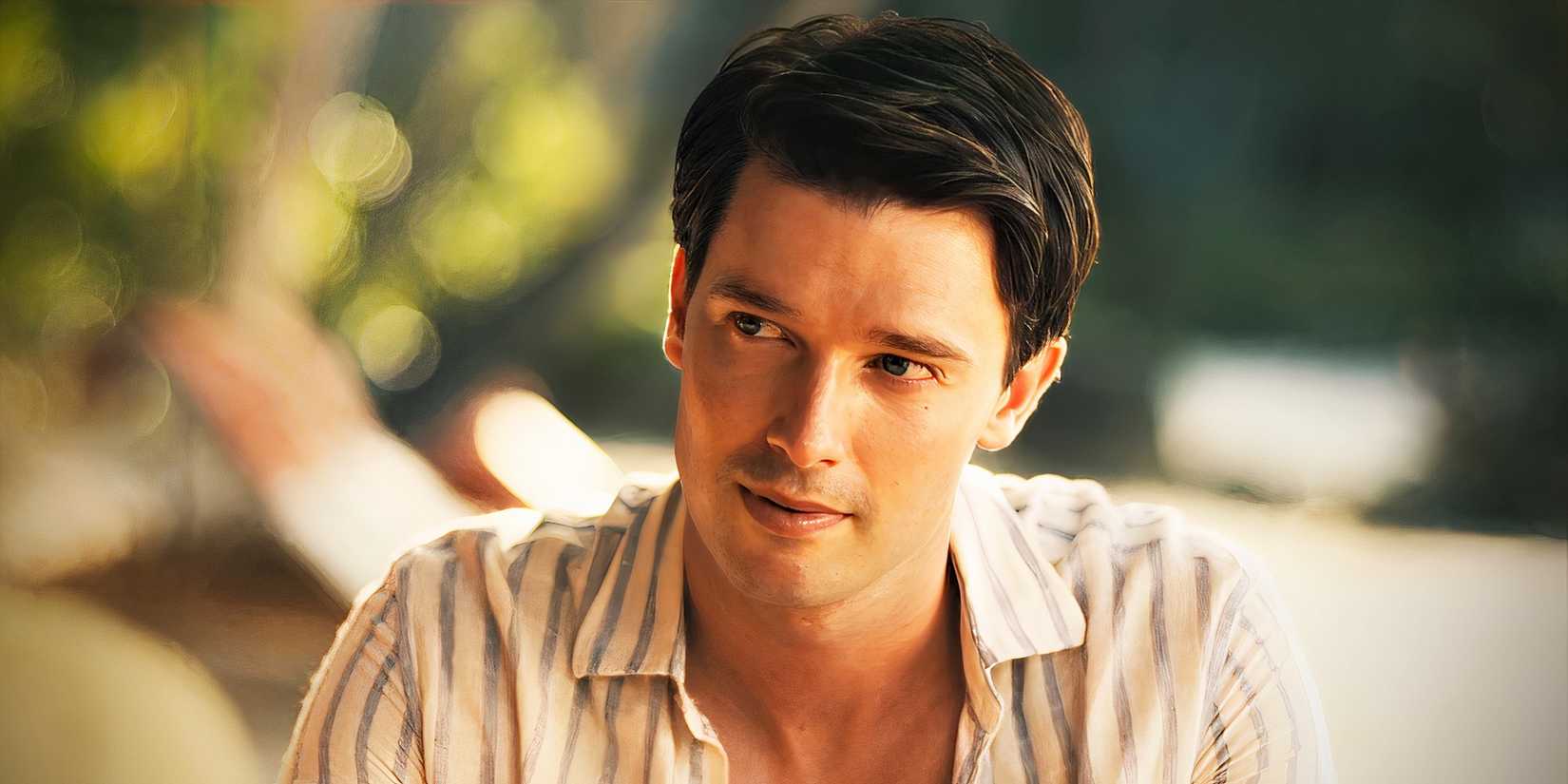 Patrick Schwarzenegger as Saxon Ratliff looking off to the side on a beach in The White Lotus