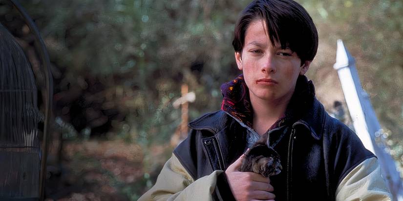 Edward Furlong looks on while holding a kitten in Pet Sematary Two